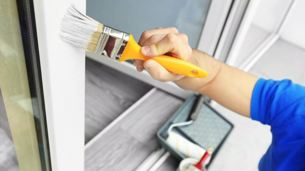 Professional applying water paint to interior wall for a smooth finish